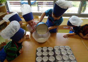 15 Dzieci przesypuja mąkę do miski